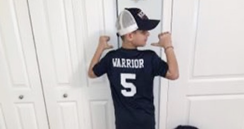 Cancer Kickers Teammate Braiden showing back of custom warrior jersey player kit nike label