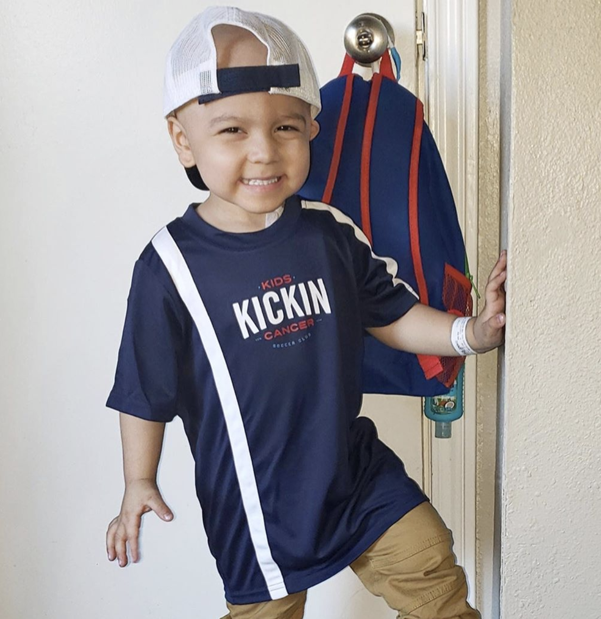 cancer kickers Teammate Domonic wearing player kit hat and jersey smiling