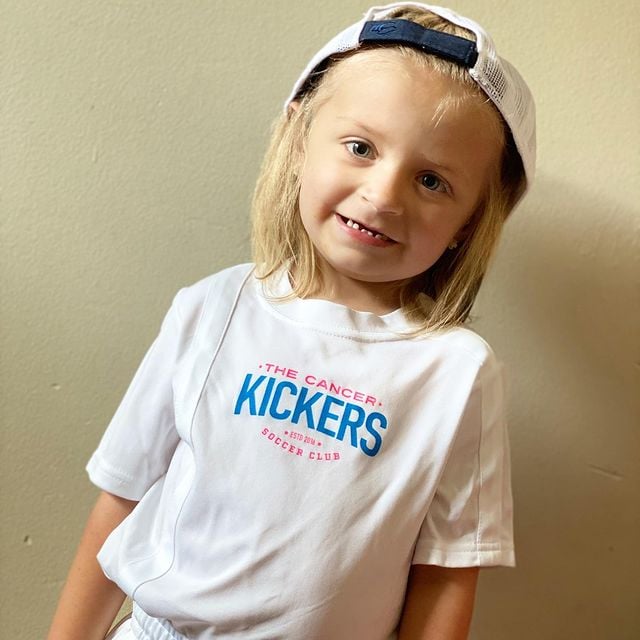Cancer Kickers Teammate with cap and white t-shirt with logo