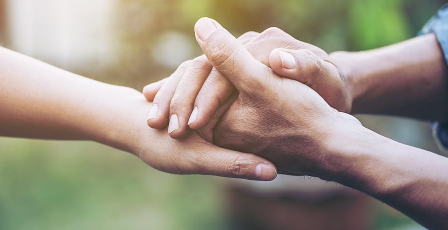 two people holding hands in support